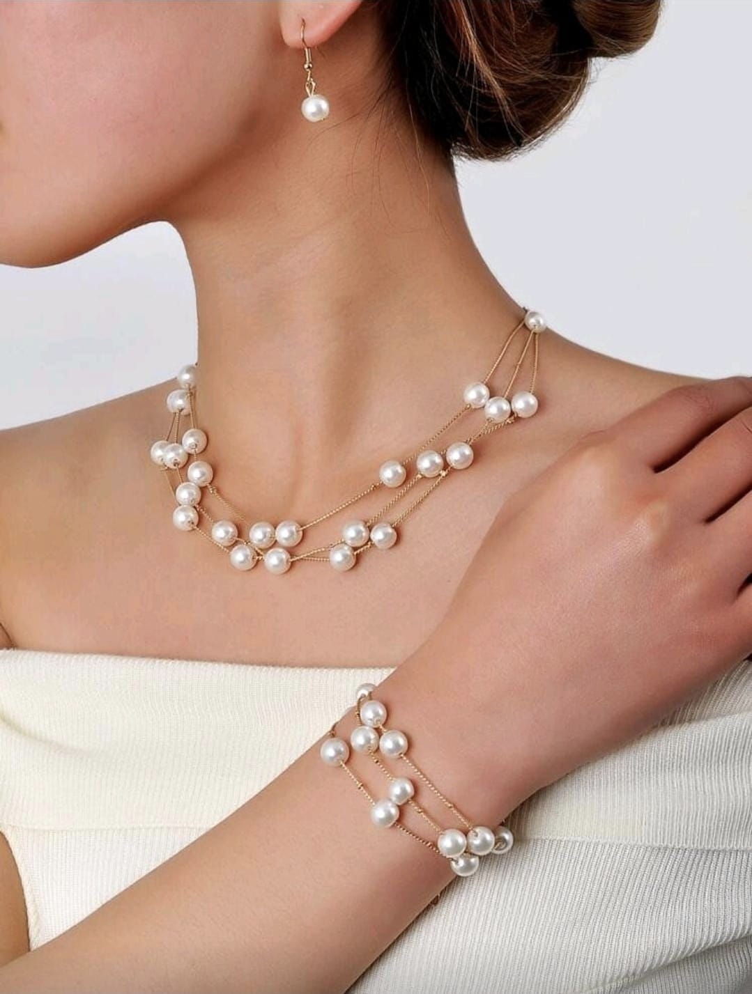 Collar, aretes y pulsera con diseño de perlas falsas.