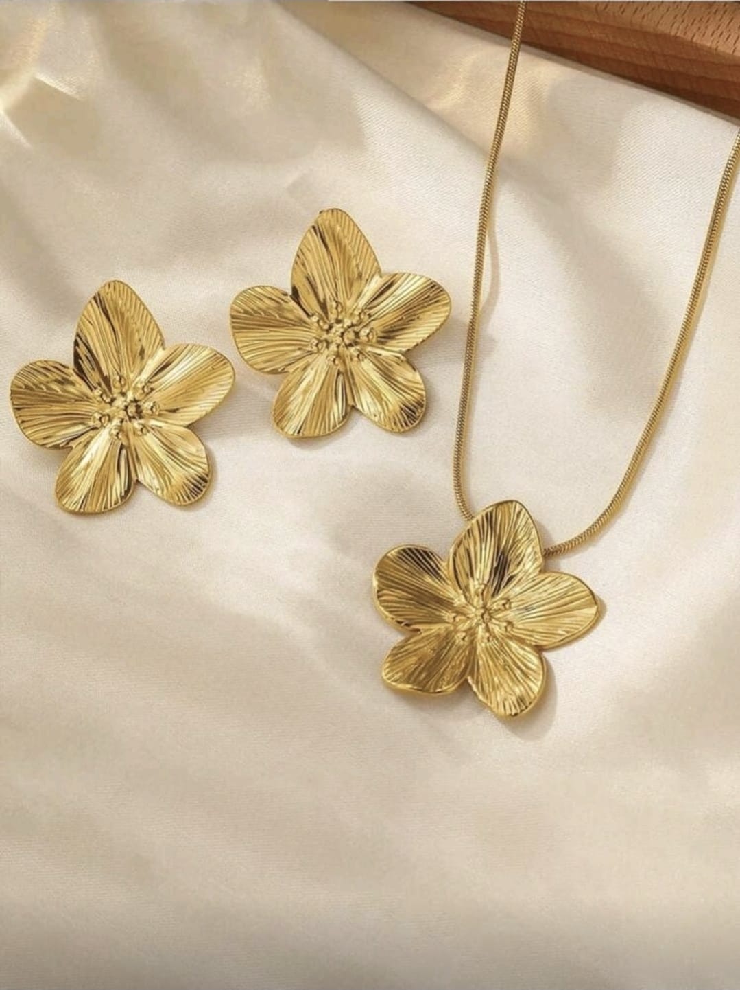 Set de collar y aretes de flor de acero inoxidable.